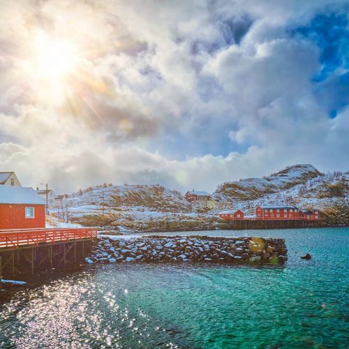 Red rorbu houses, Lofoten islands, Norway Red rorbu houses of Sakrisoy village with snow in winter. Lofoten islands, Norway